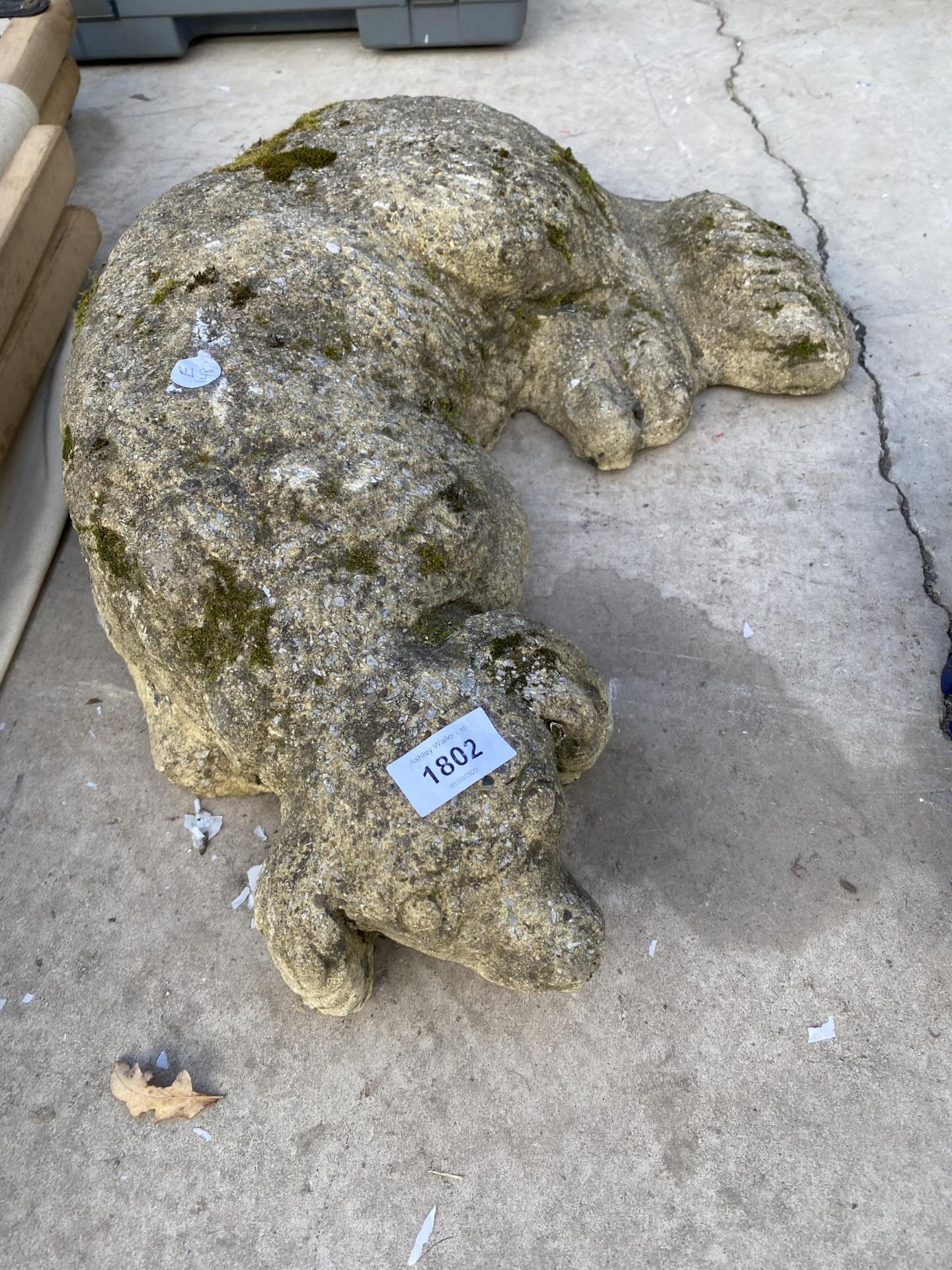 A RECONSTITUTED STONE DOG GARDEN FIGURE