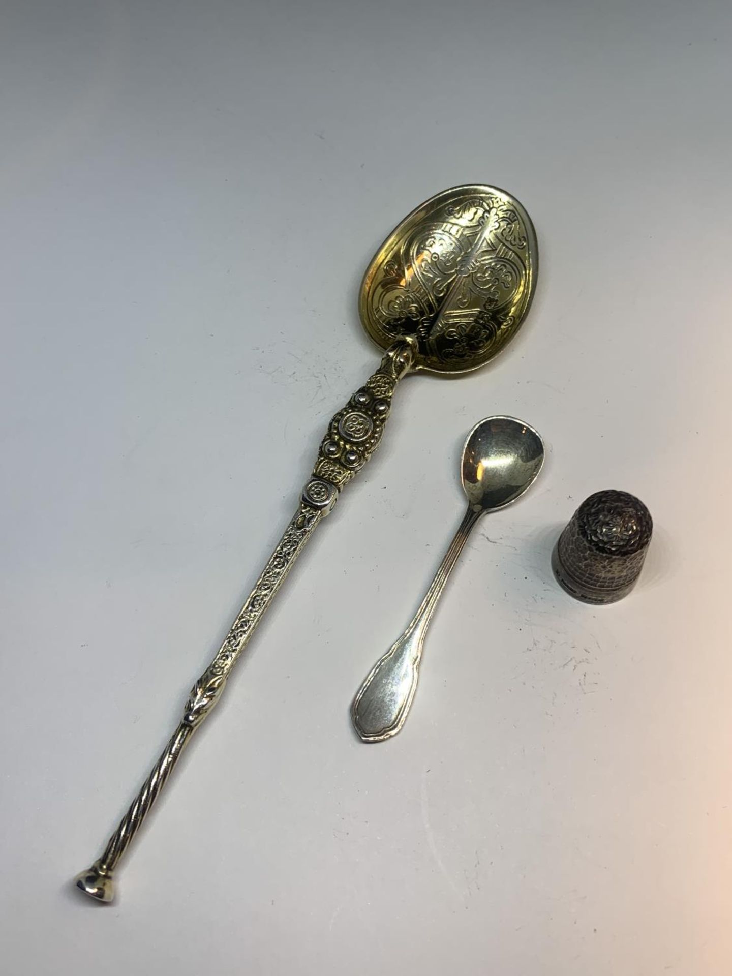 THREE HALLMARKED SILVER ITEMS TO INCLUDE TWO SPOONS AND A THIMBLE