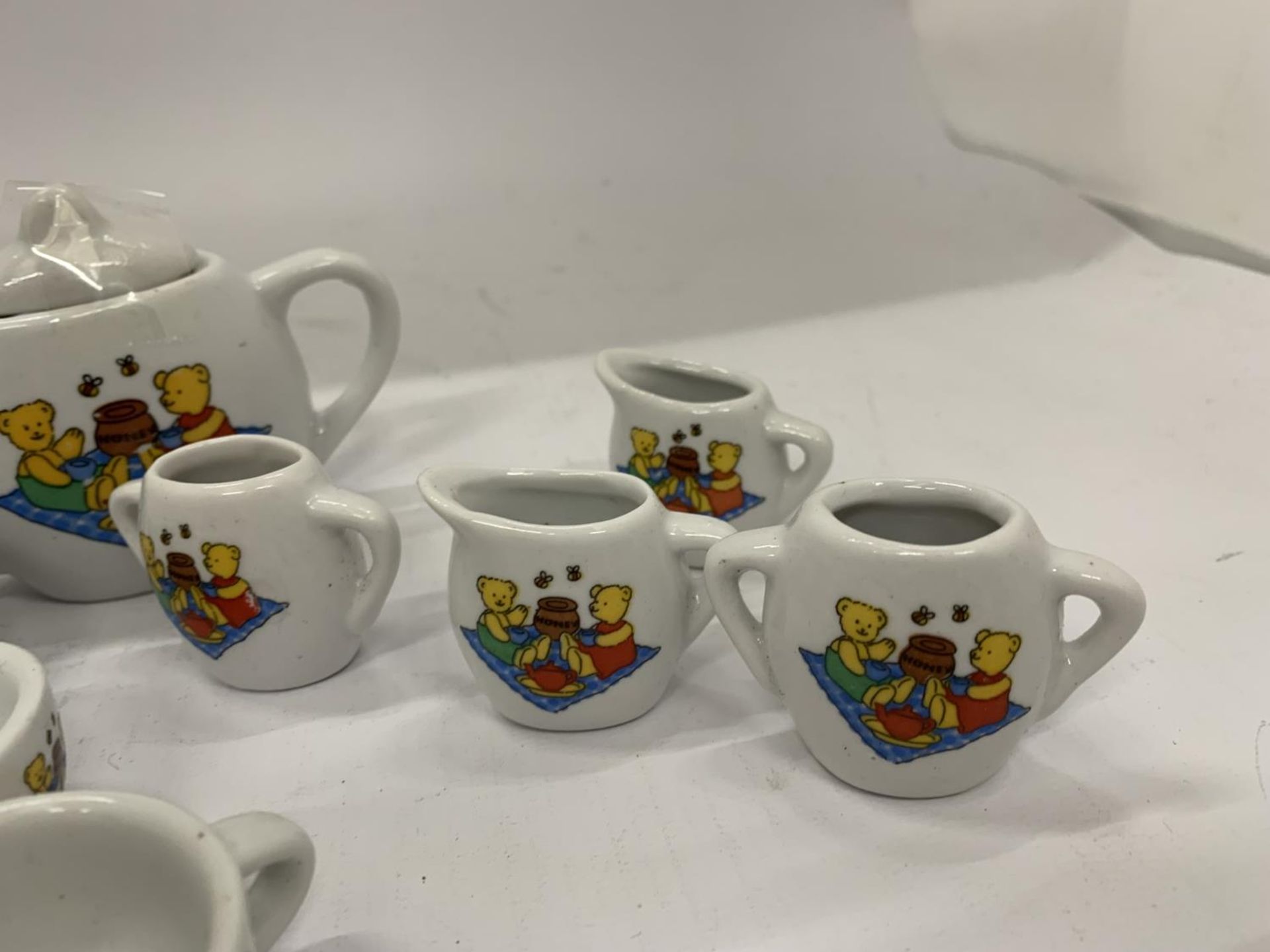 A MINIATURE CHILD'S POTTERY TEASET TO INCLUDE TEAPOT, JUGS, CUPS, ETC WITH A TEDDY BEARS PICNIC - Image 8 of 10
