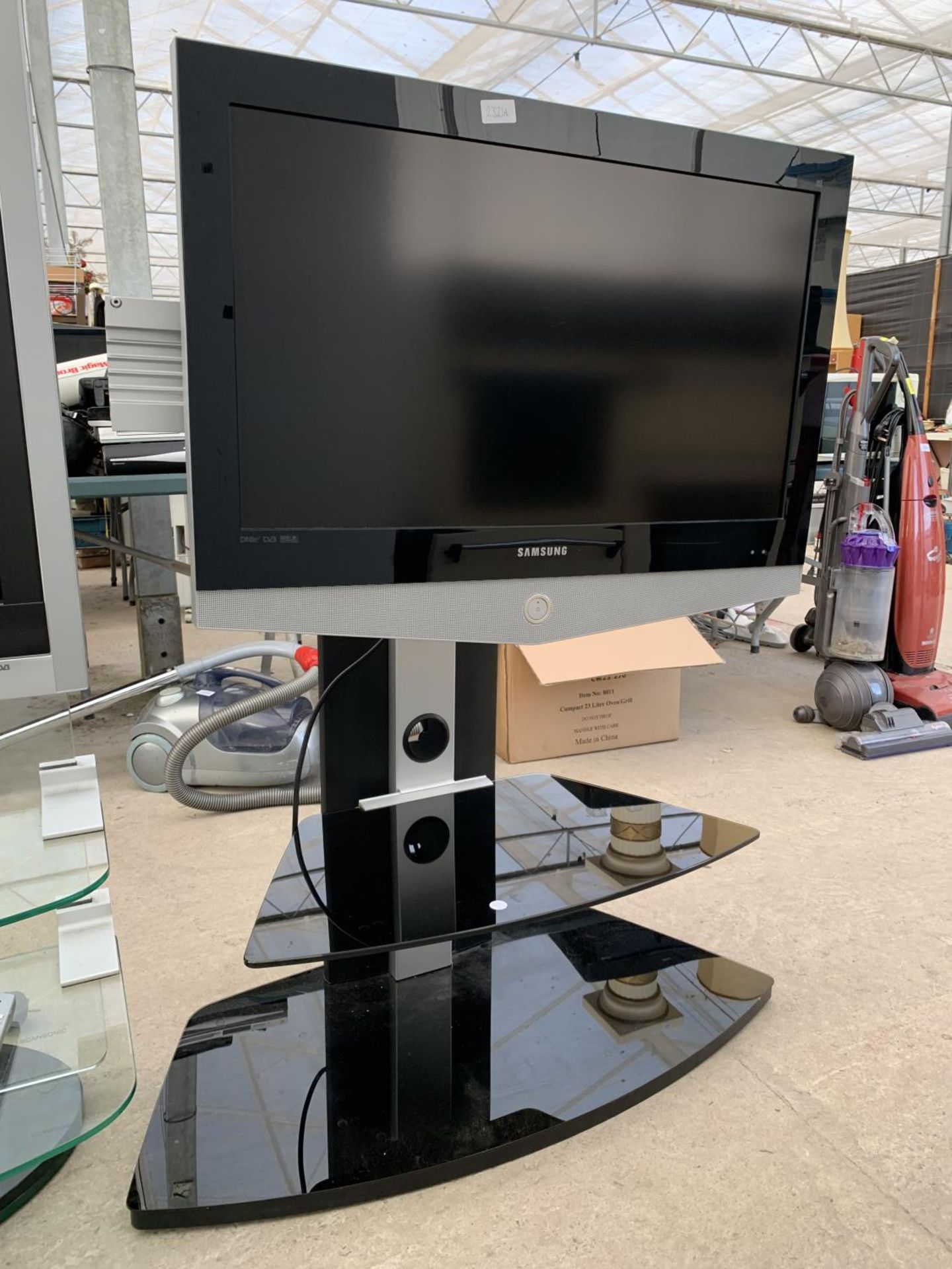 A SAMSUNG 32" TELEVISIOV ON GLASS DISPLAY STAND