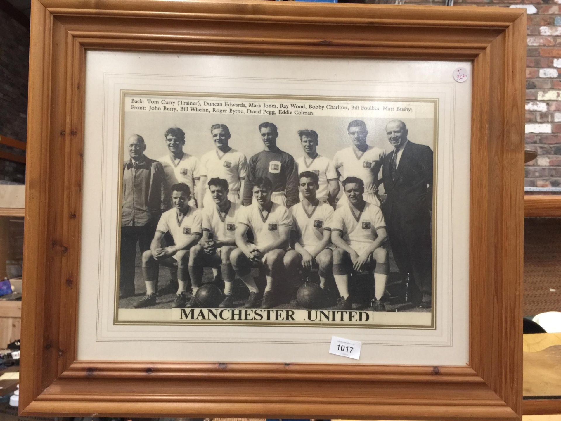 A FRAMED PRINT OF MANCHESTER UNITED WITH SIR MATT BUSBY AND THE BUSBY BABES