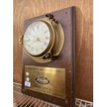 A BRASS PORTHOLE STYLE SALOON WALL CLOCK WITH WOODEN MOUNT BEARING THE PLAQUE 'NORTHERN AREA