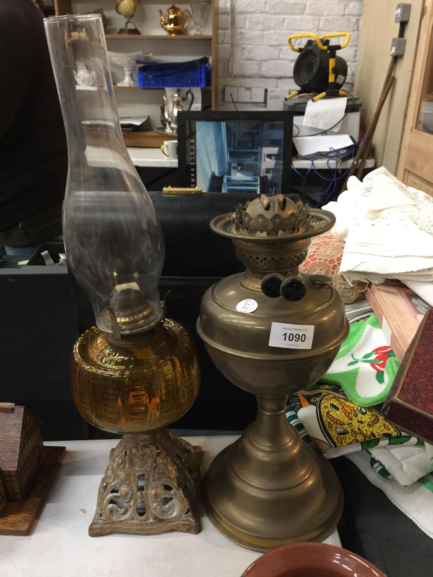 TWO VINTAGE OIL LAMPS ONE WITH A PIERCED BRASS BASE AND AMBER GLASS MIDDLE