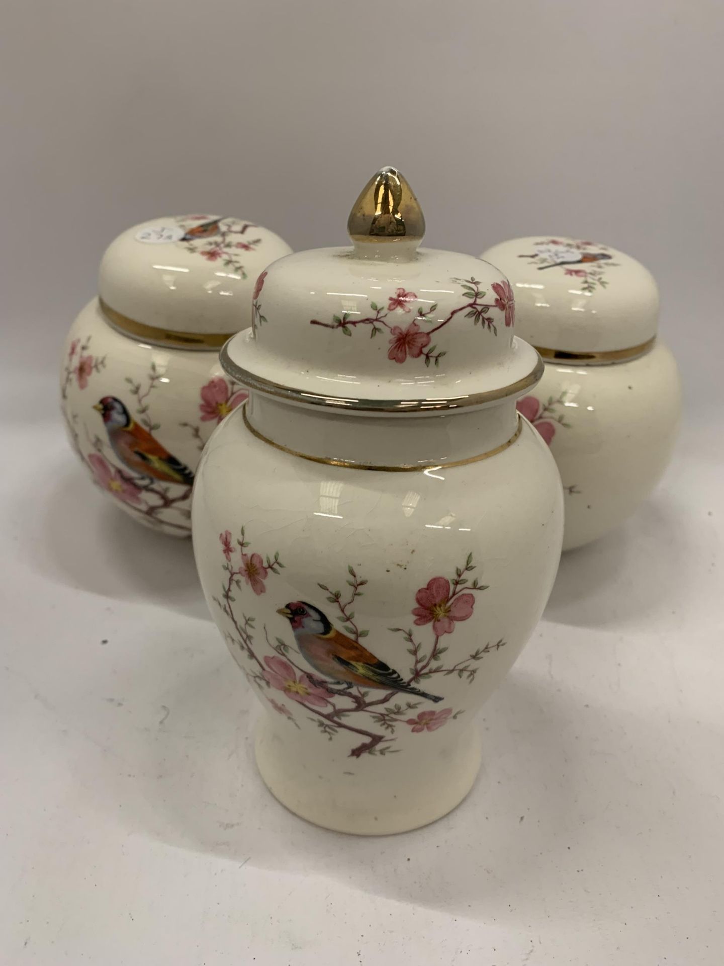 TWO ARTHUR WOOD GINGER JARS AND A TEMPLE JAR WITH BIRDS AND BLOSSOM DESIGN