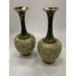 A PAIR OF ROYAL DOULTON VASES WITH SLIM NECKS AND GREEN PATTERN - BOTH A/F