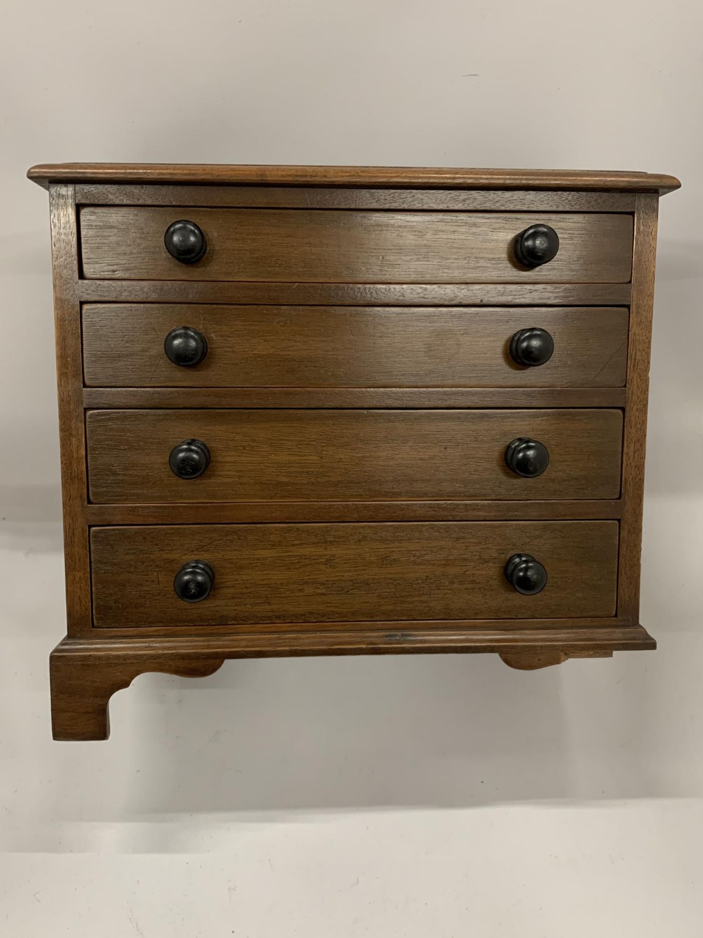 A MAHOGANY FOUR DRAWER TABLE TOP CHEST OF DRAWERS, HEIGHT 28CM