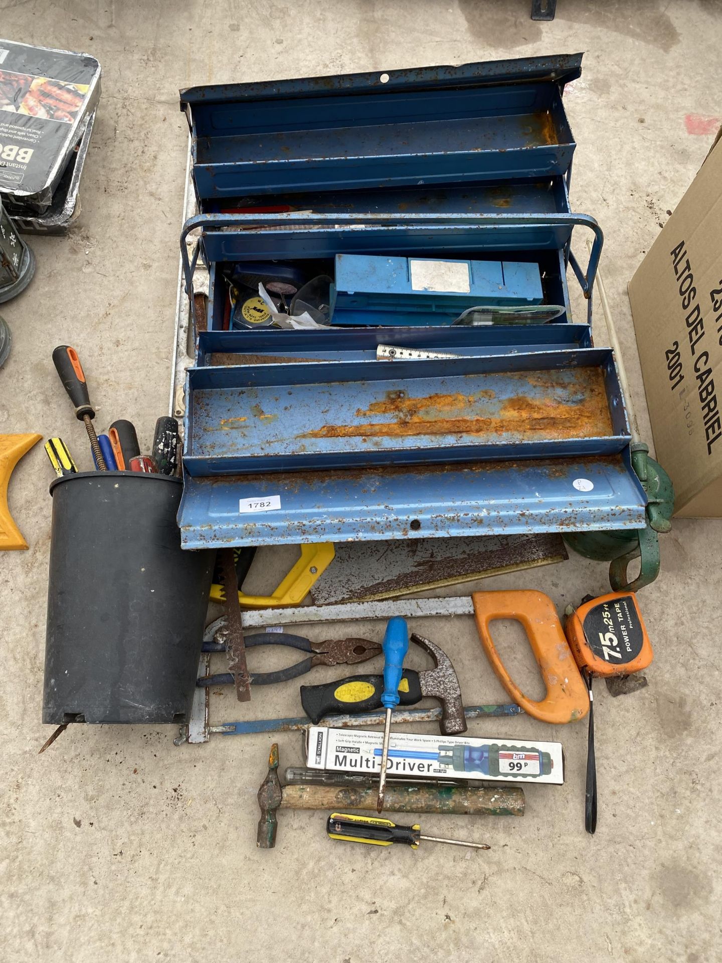 A METAL TOOL BOX CONTAINING AN ASSORTMENT OF TOOLS TO INCLUDE AN OIL CAN, HAMMERS AND PLIERS ETC