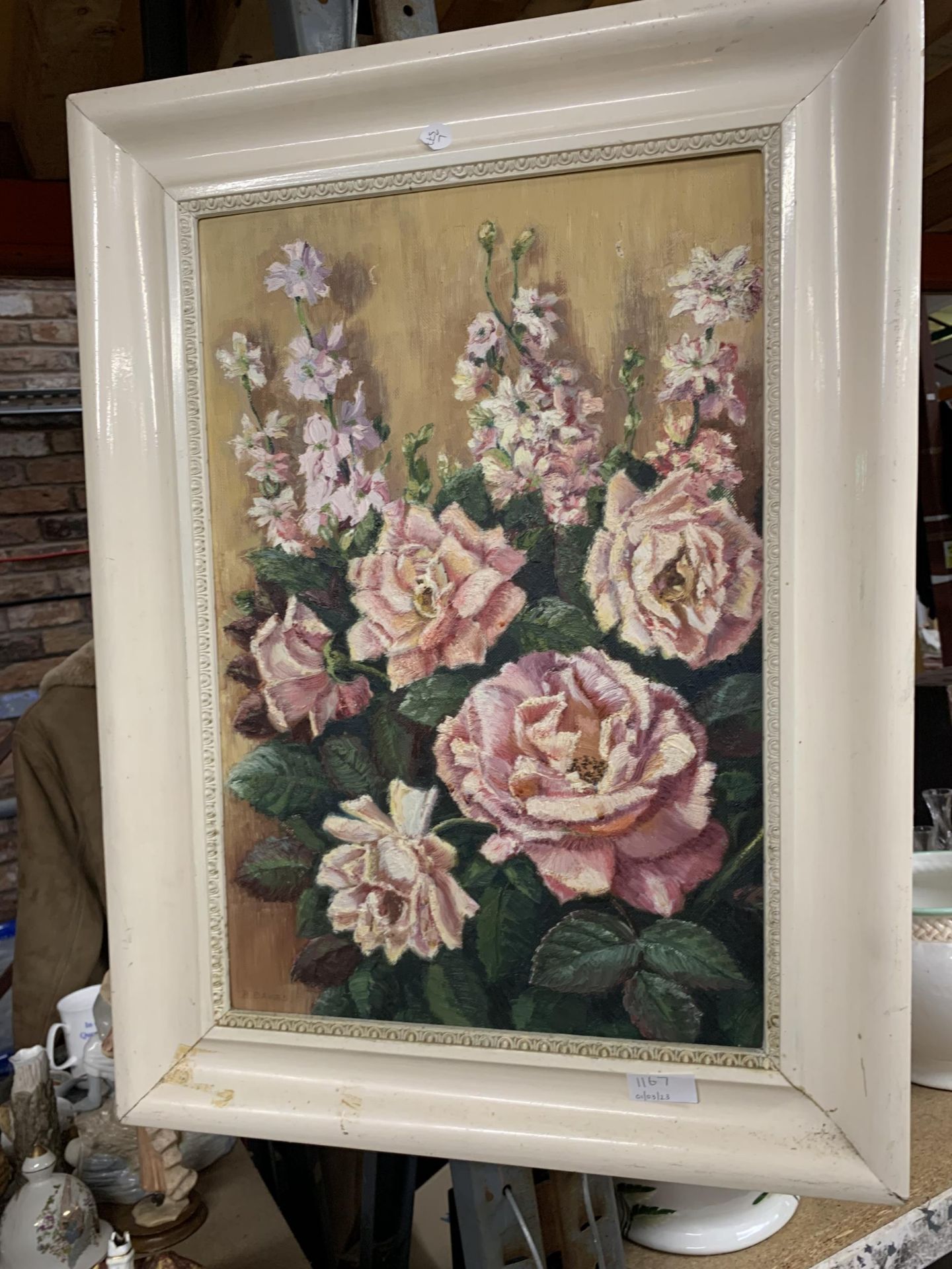 AN OIL ON BOARD PAINTING OF ROSES IN A CREAM FRAME