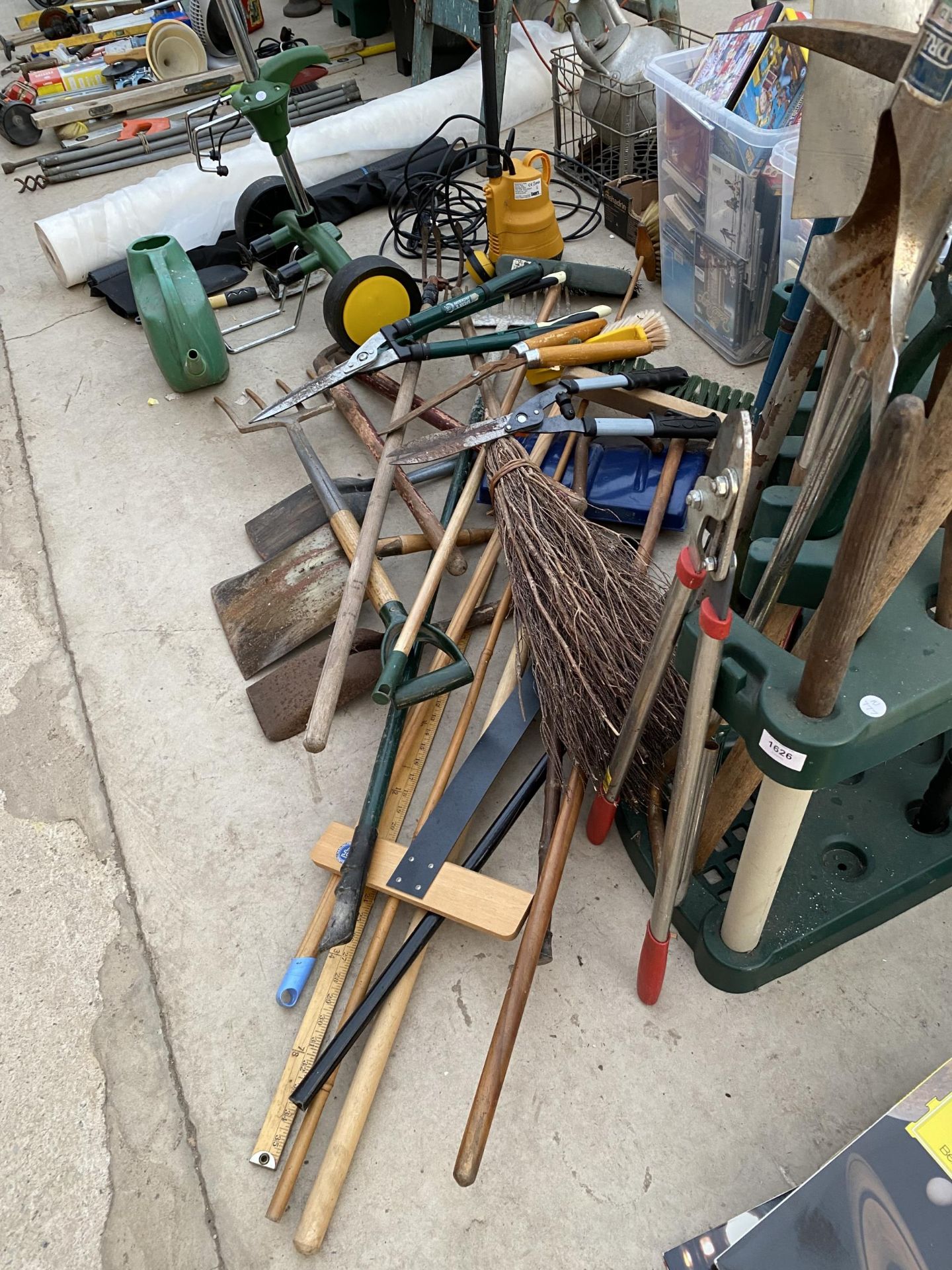 A LARGE ASSORTMENT OF GARDEN TOOLS TO INCLUDE A PICK AXE, FORKS AND RAKES TO ALSO INCLUDE A PLANT - Image 2 of 5