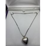 A SILVER NECKLACE WITH A HEART PENDANT IN A PRESENTATION BOX