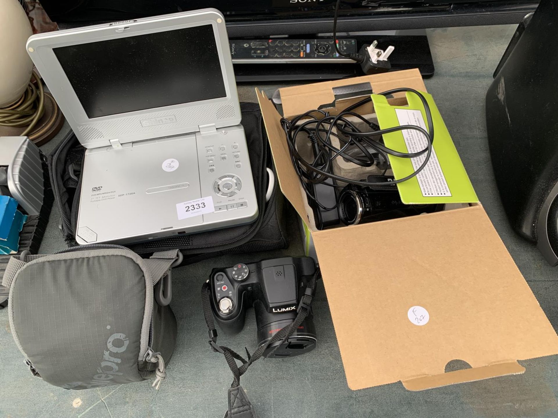 AN ASSORTMENT OF ITEMS TO INCLUDE A LUMIX CAMERA, A SHINCO PORTABLE DVD PLAYER AND A JVC CAMCORDER