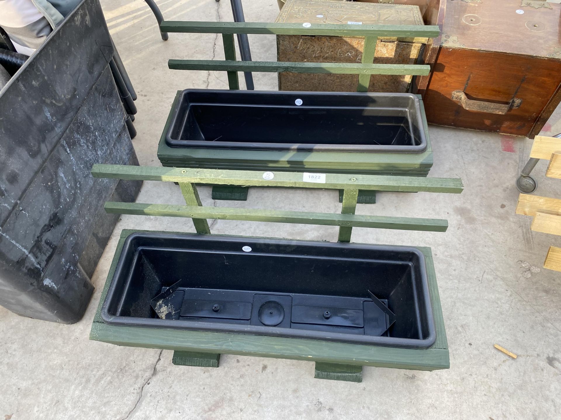 TWO WOODEN TROUGH PLANTERS WITH PLASTIC LINERS AND TRELIS SUPPORTS