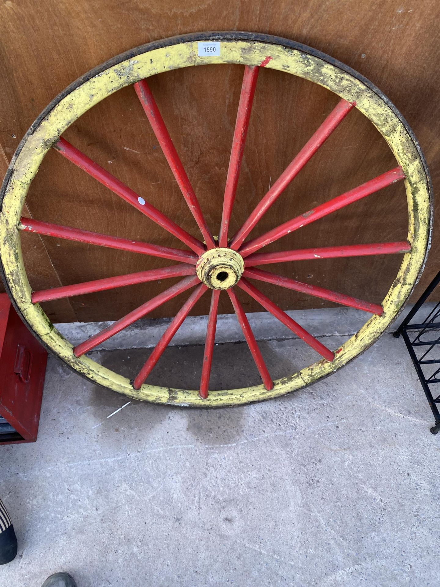 A WOODEN CART WHEEL WITH METAL BANDING