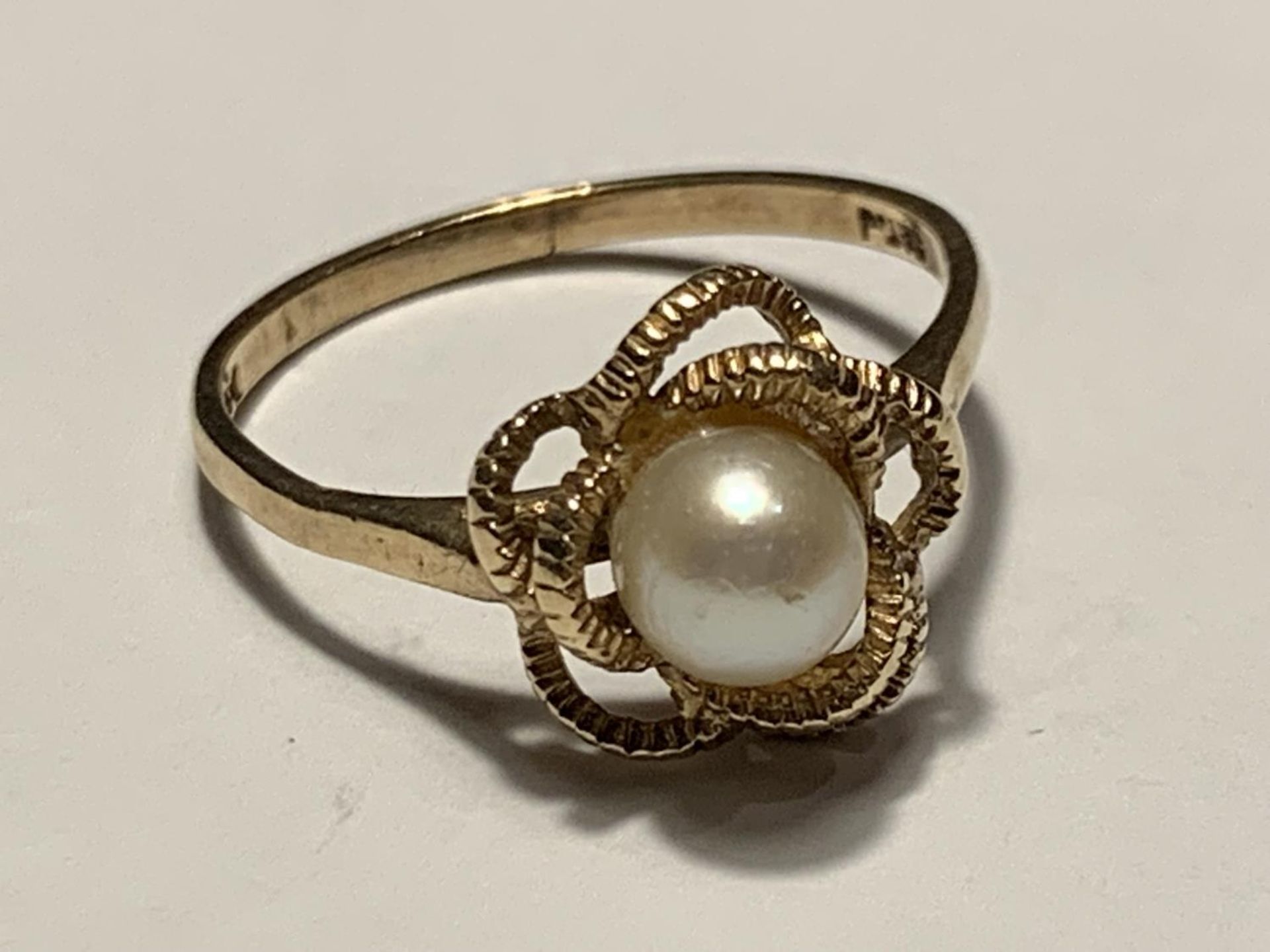 A 9 CARAT GOLD RING WITH A CENTRE PEARL IN A TWIST DESIGN SIZE O/P - Image 2 of 6