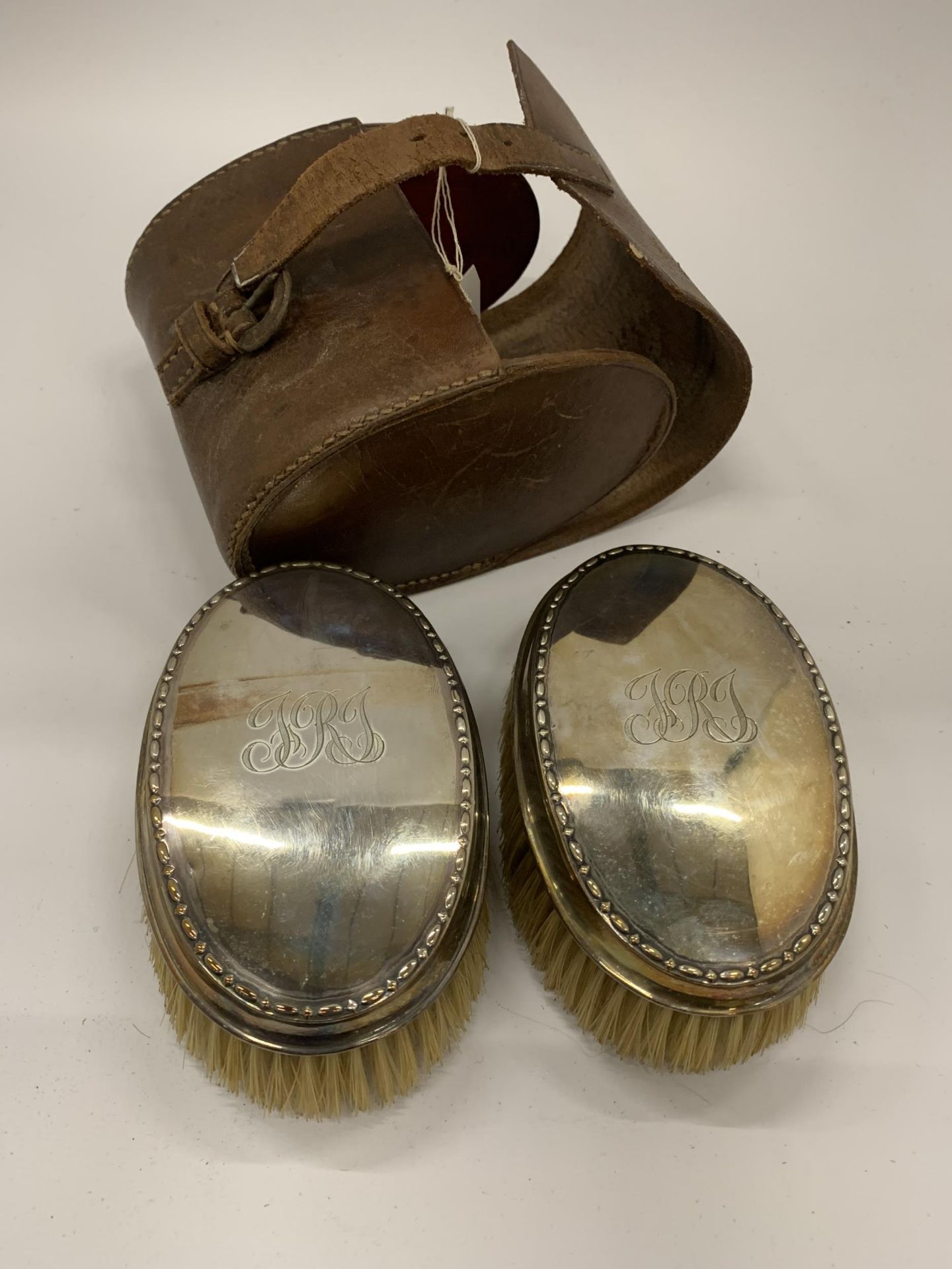 A CASED PAIR OF HALLMARKED SILVER BACKED CLOTHES BRUSHES