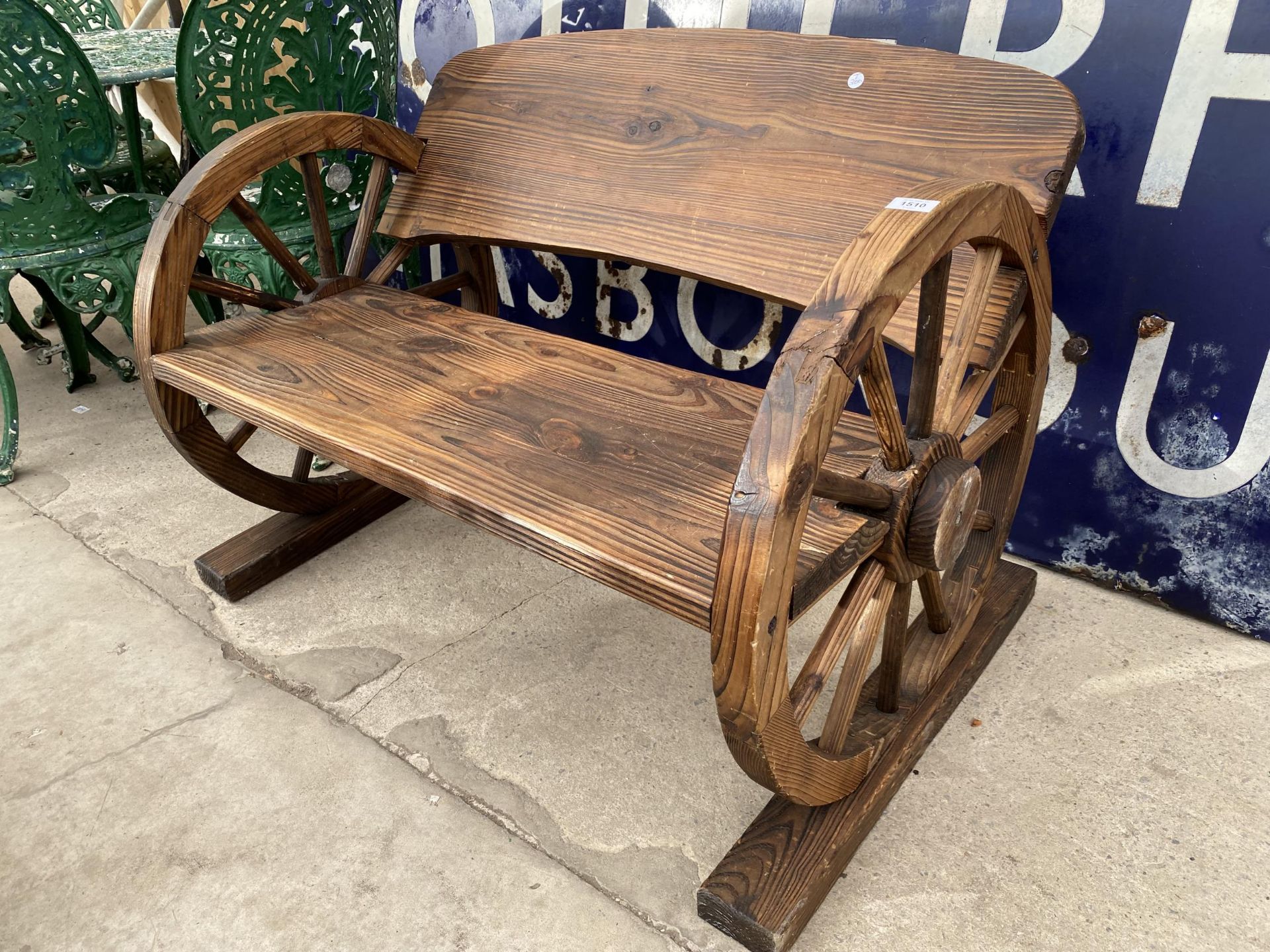 A WOODEN GARDEN TWO SEATER BENCH WITH CART WHEEL BENCH ENDS (L:98CM)
