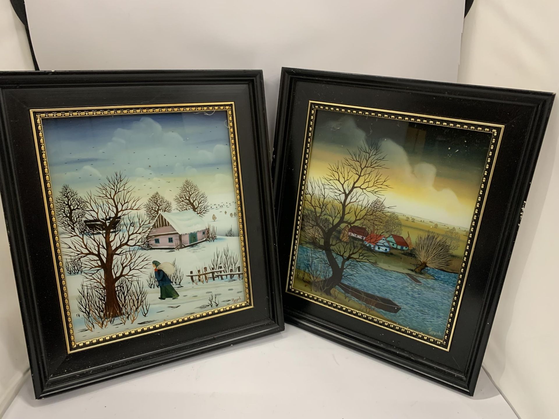 A PAIR OF EBONY FRAMED SIGNED OIL ON GLASS PANELS, SIGNED HURJZAK, '78, 34 X 39CM