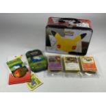 A POKEMON 25TH ANNIVERSARY TIN WITH ASSORTED CARDS, GAME TOKENS ETC