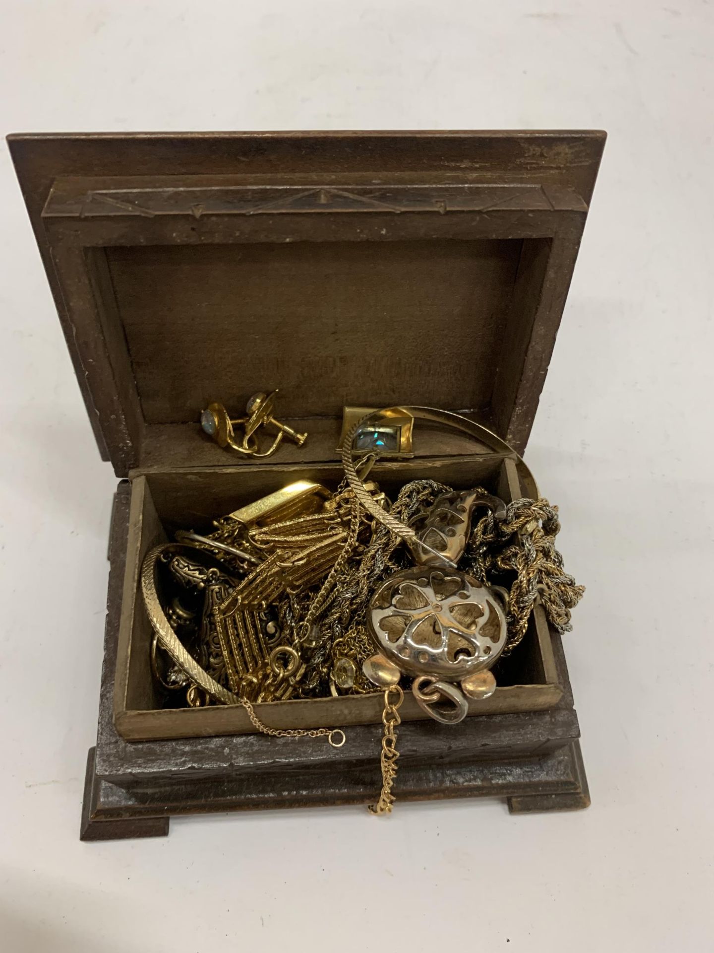 A QUANTITY OF YELLOW METAL COSTUME JEWELLERY TO INCLUDE CHAINS, EARRINGS, ETC IN A WOODEN BOX
