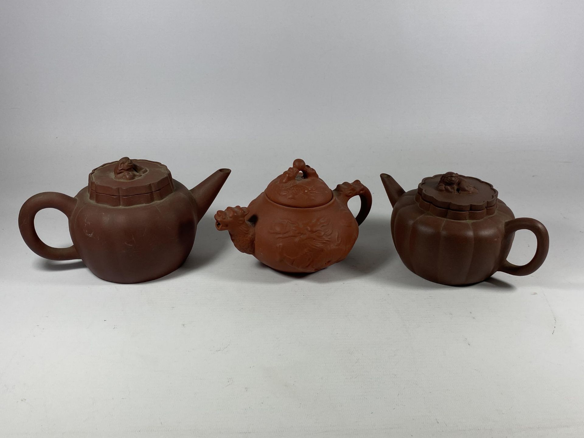 A GROUP OF THREE CHINESE YIXING CLAY TEAPOTS, LARGEST 10.5CM