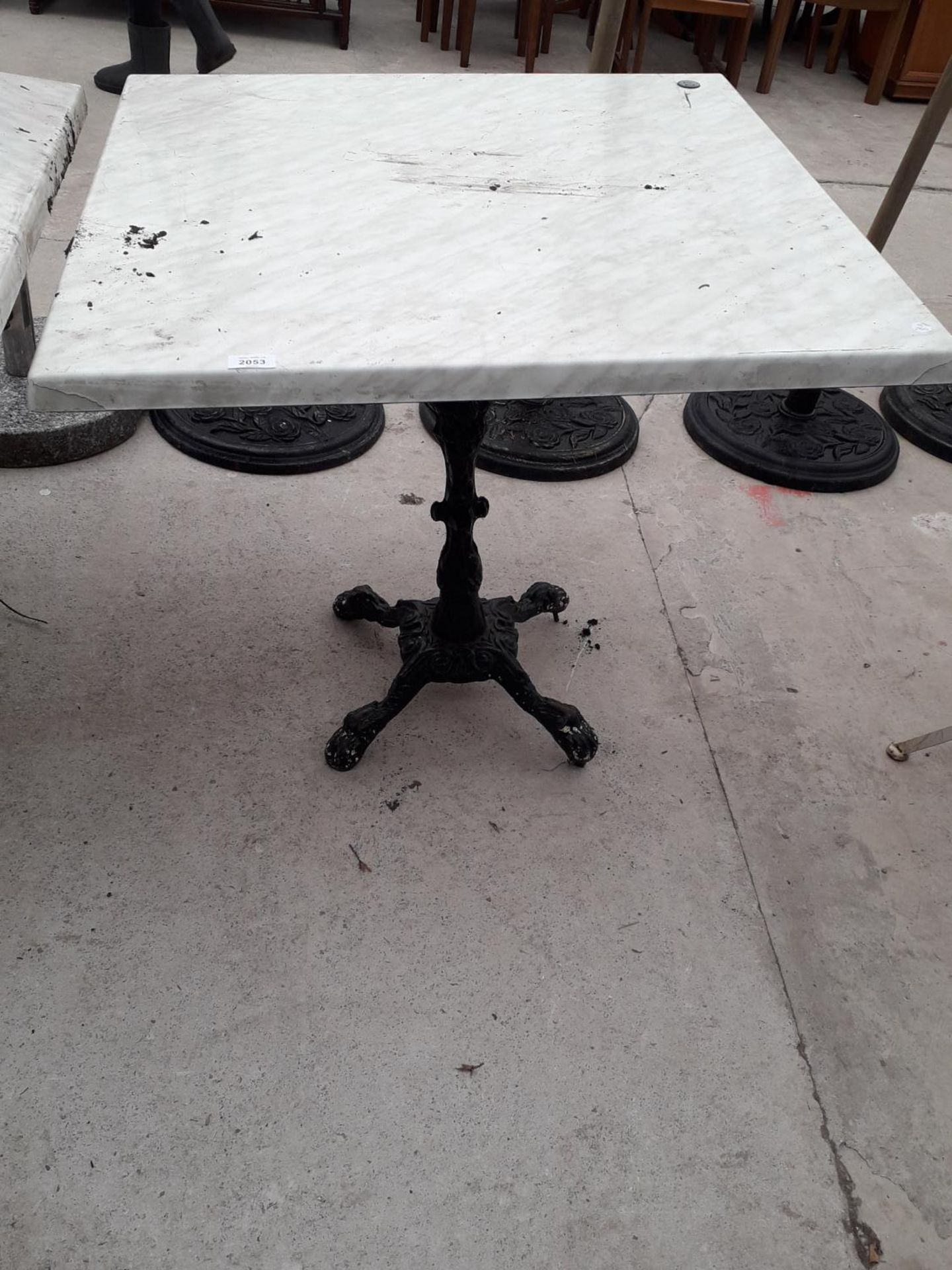 A PUB TABLE WITH WOODEN TOP AND CAST IRON TABLE BASE (79CM x 79CM)