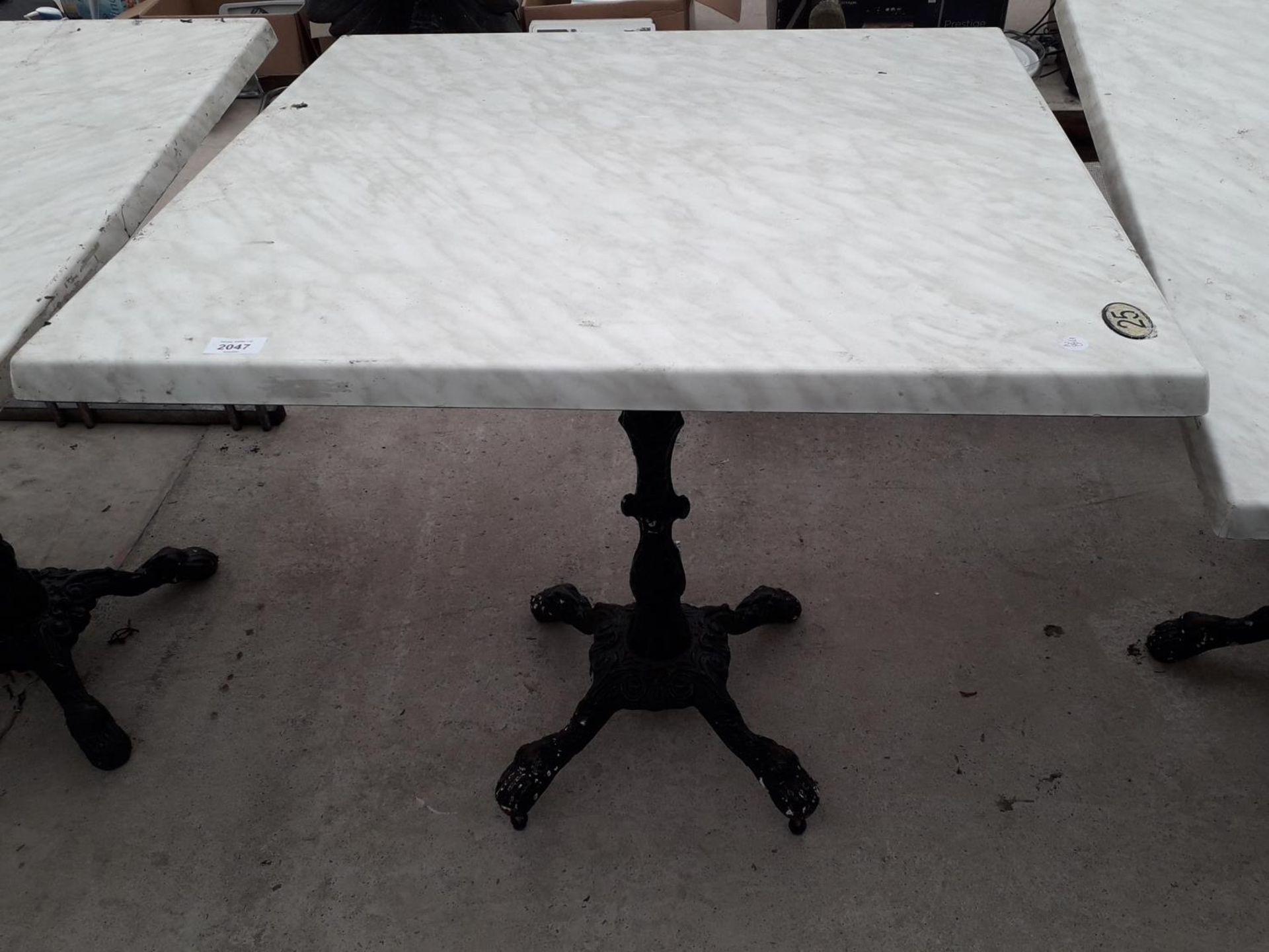 A PUB TABLE WITH WOODEN TOP AND CAST IRON TABLE BASE (79CM x 79CM)