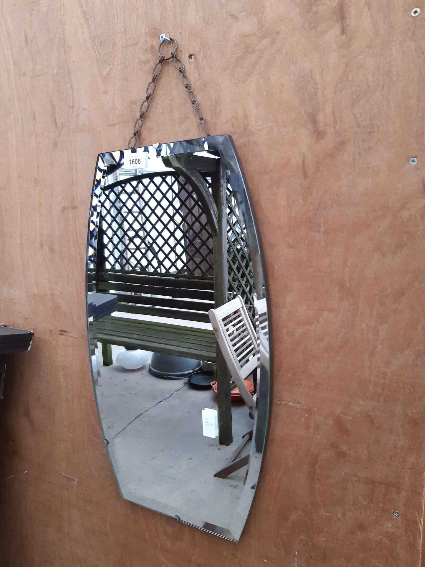 A CURVED ART DECO STYLE UNFRAMED BEVELED EDGE WALL MIRROR WITH HANGING CHAIN