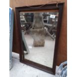 A WOODEN FRAMED BEVELED EDGE WALL MIRROR