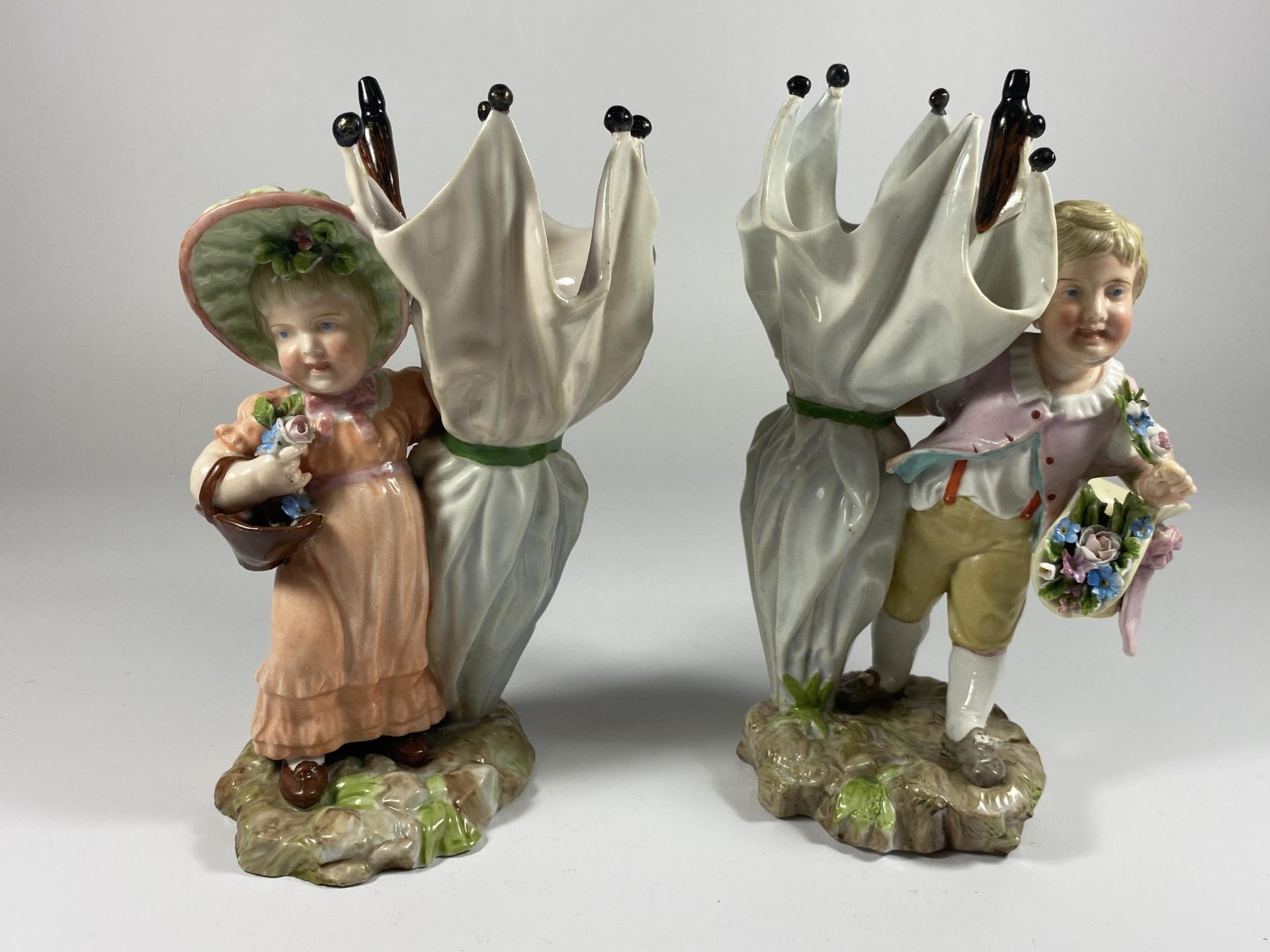 A PAIR OF 19TH CENTURY DRESDEN STYLE CONTINENTAL HARD PASTE PORCELAIN FIGURES WITH CROSSED SWORD