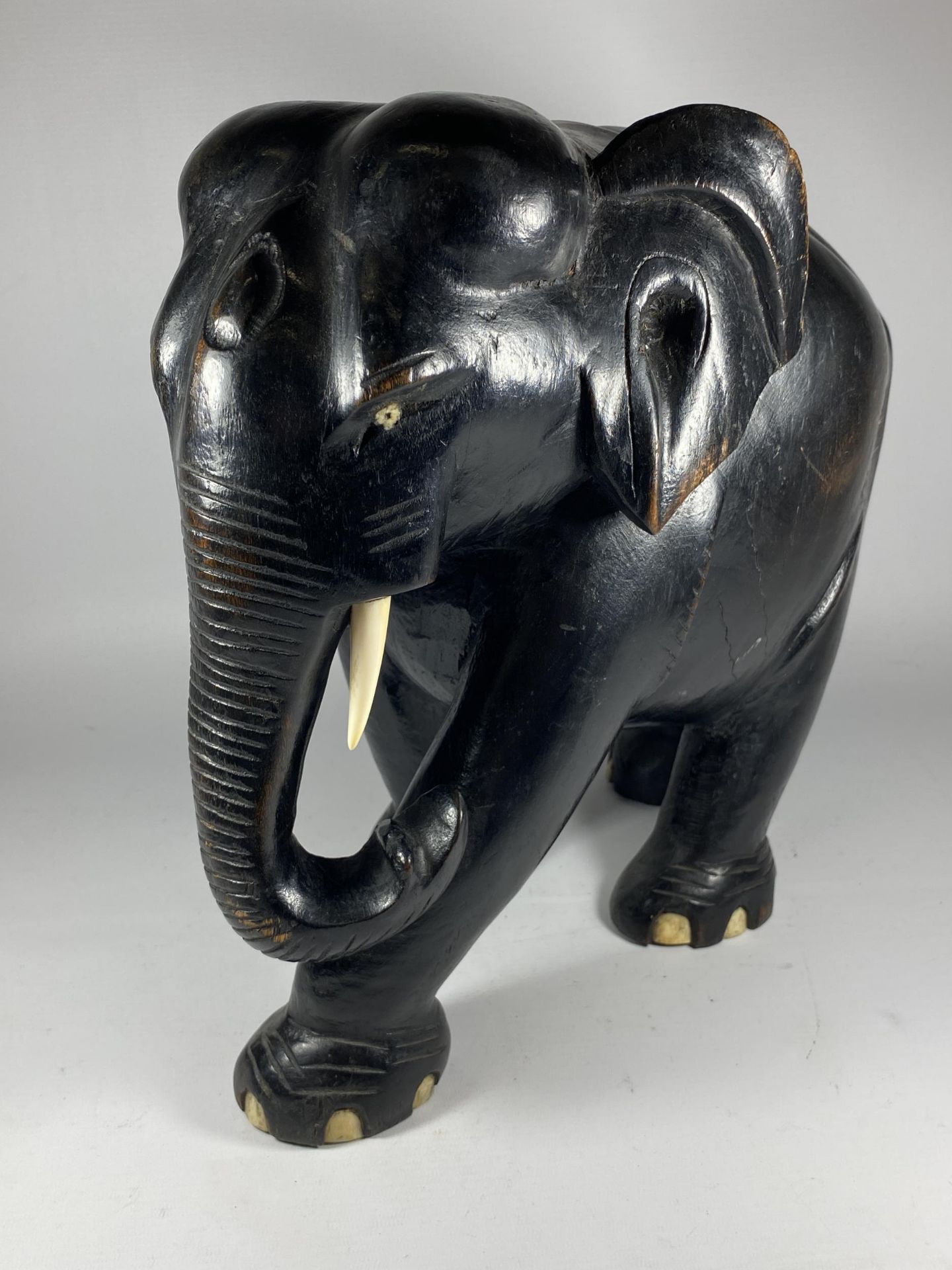 A LARGE HEAVY ANTIQUE EBONISED WOODEN ELEPHANT MODEL, HEIGHT 38CM