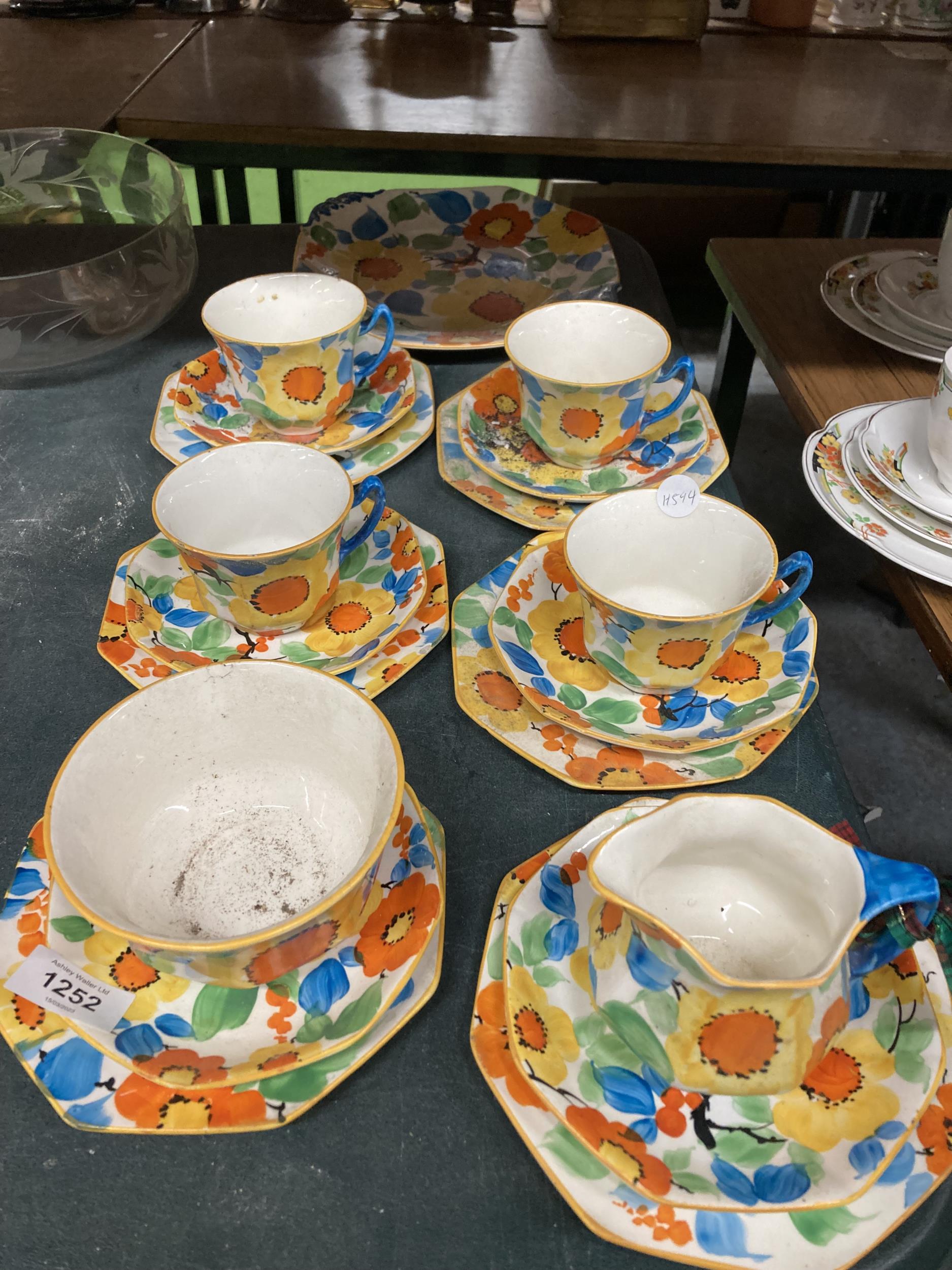 A VINTAGE TEASET IN A FLORAL DESIGN TO INCLUDE A CAKE PLATE, CUPS, SAUCERS, SIDE PLATES, A CREAM JUG