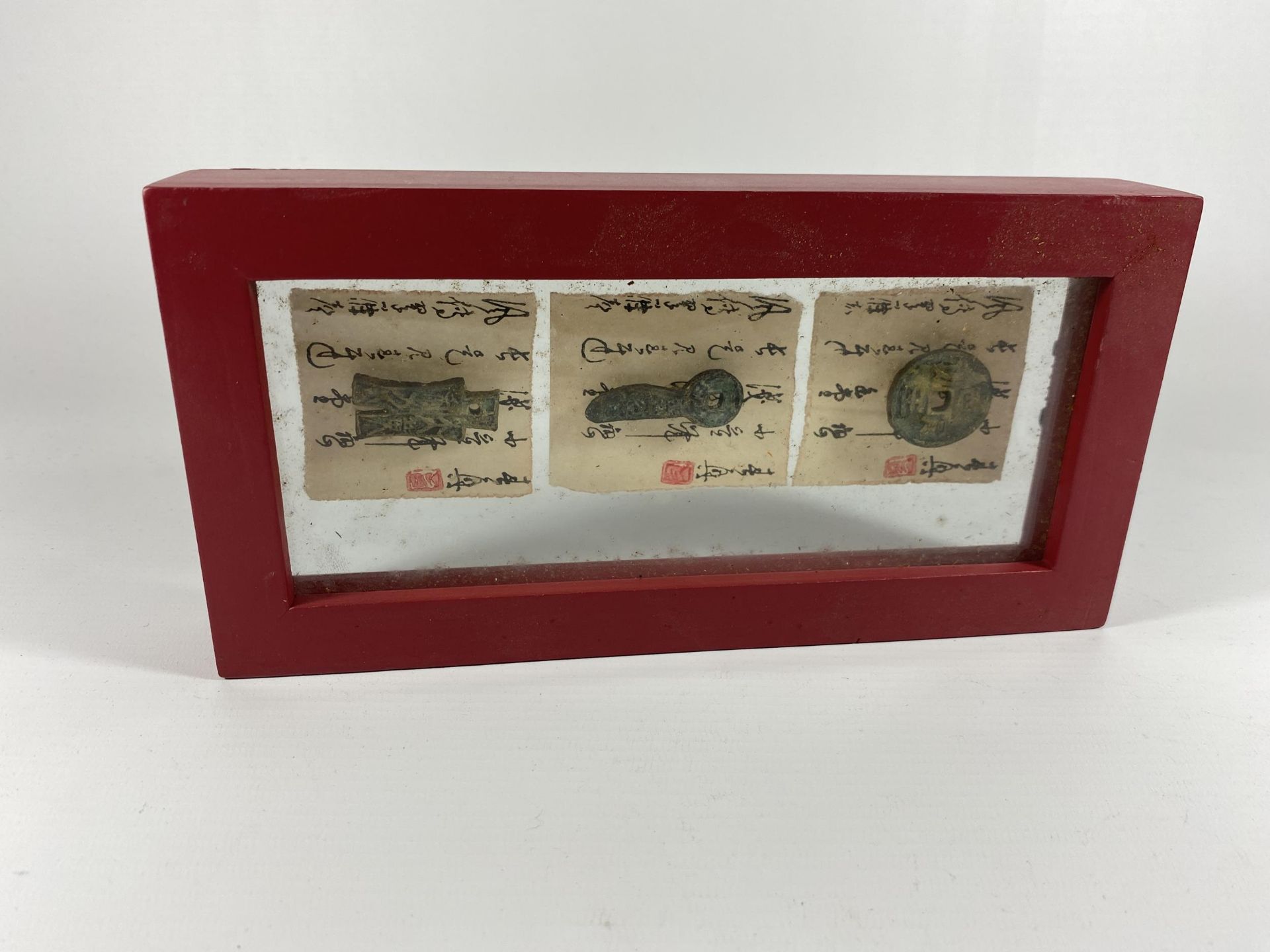 AN ORIENTAL FRAMED ARTIFACT DISPLAY