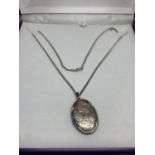 A SILVER NECKLACE WITH A SILVER LOCKET IN A PRESENTATION BOX