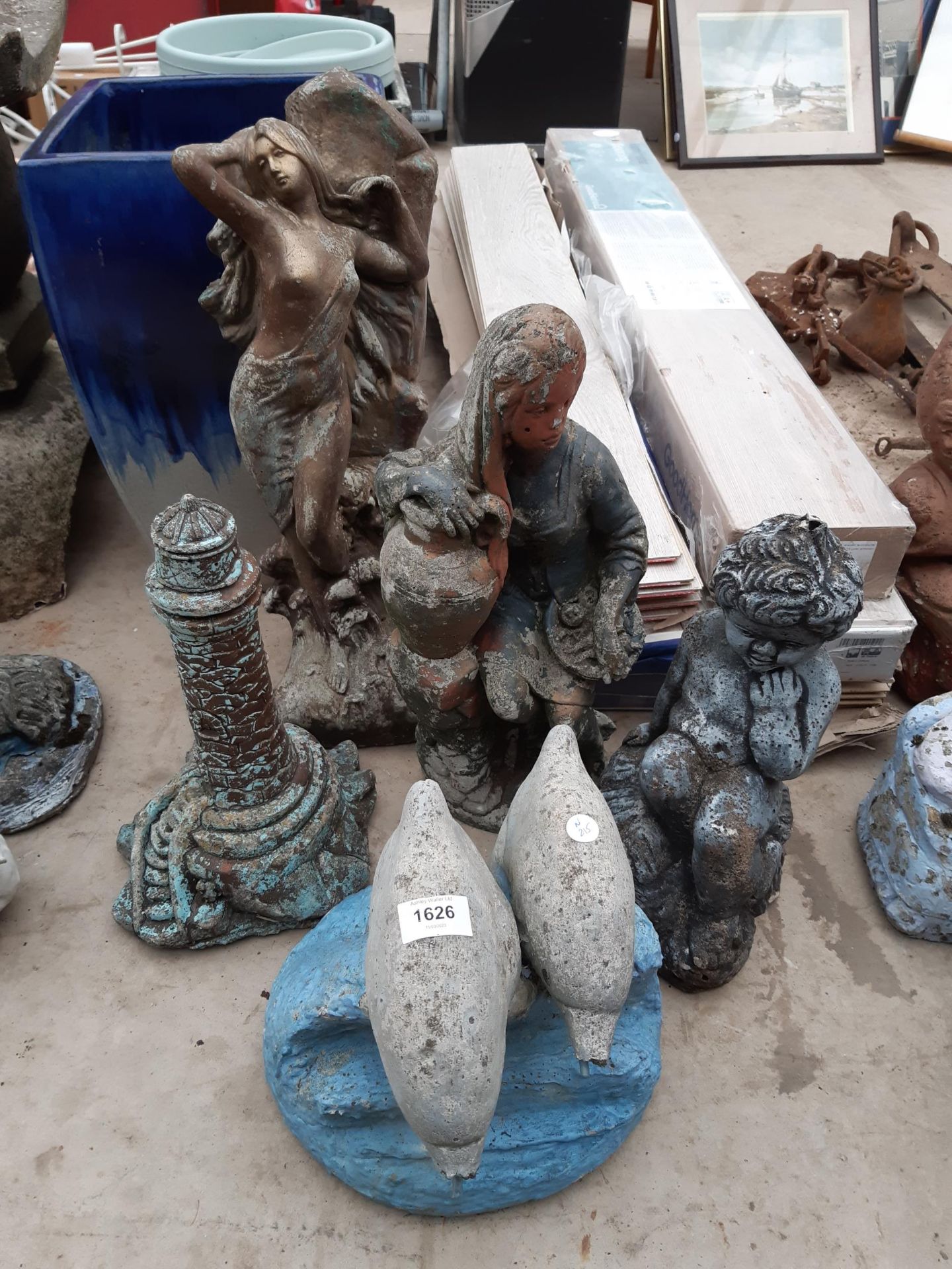FIVE VARIOUS RECONSTITUTED STONE GARDEN FIGURES TO INCLUDE A LIGHTHOUSE AND DOLPHINS ETC