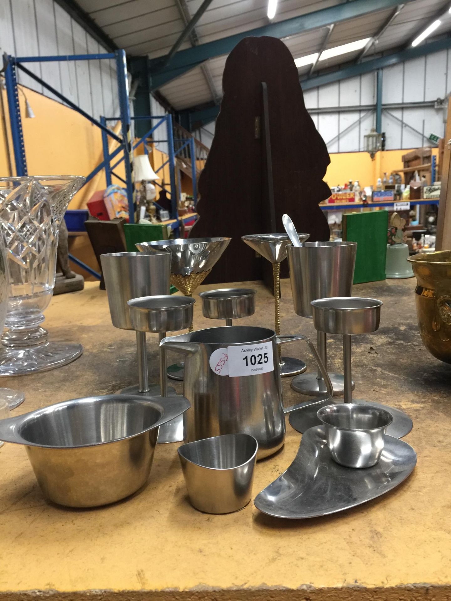 A QUANTITY OF STAINLESS STELL ITEMS TO INCLUDE CANDLEHOLDERS, JUGS, DRINKING VESSELS, ETC