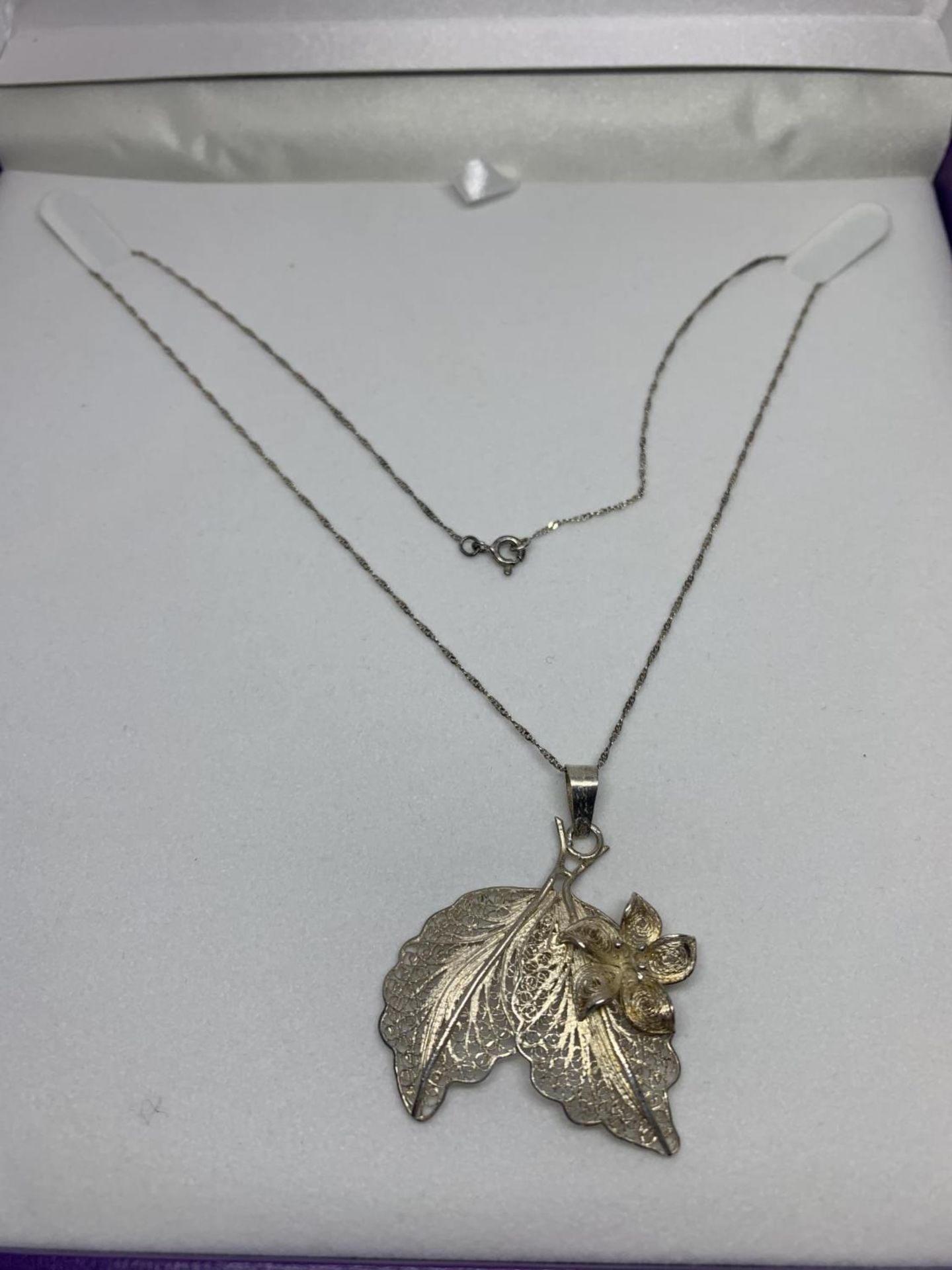 A SILVER LEAF DESIGN PENDANT IN A PRESENTATION BOX