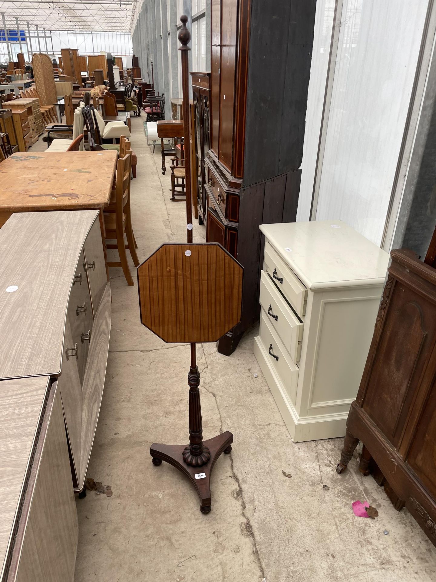 A REGENCY MAHOGANY POLE SCREENON TURNED AND FLUTED COLUMN