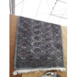 A BLACK PATTERNED FRINGED RUG