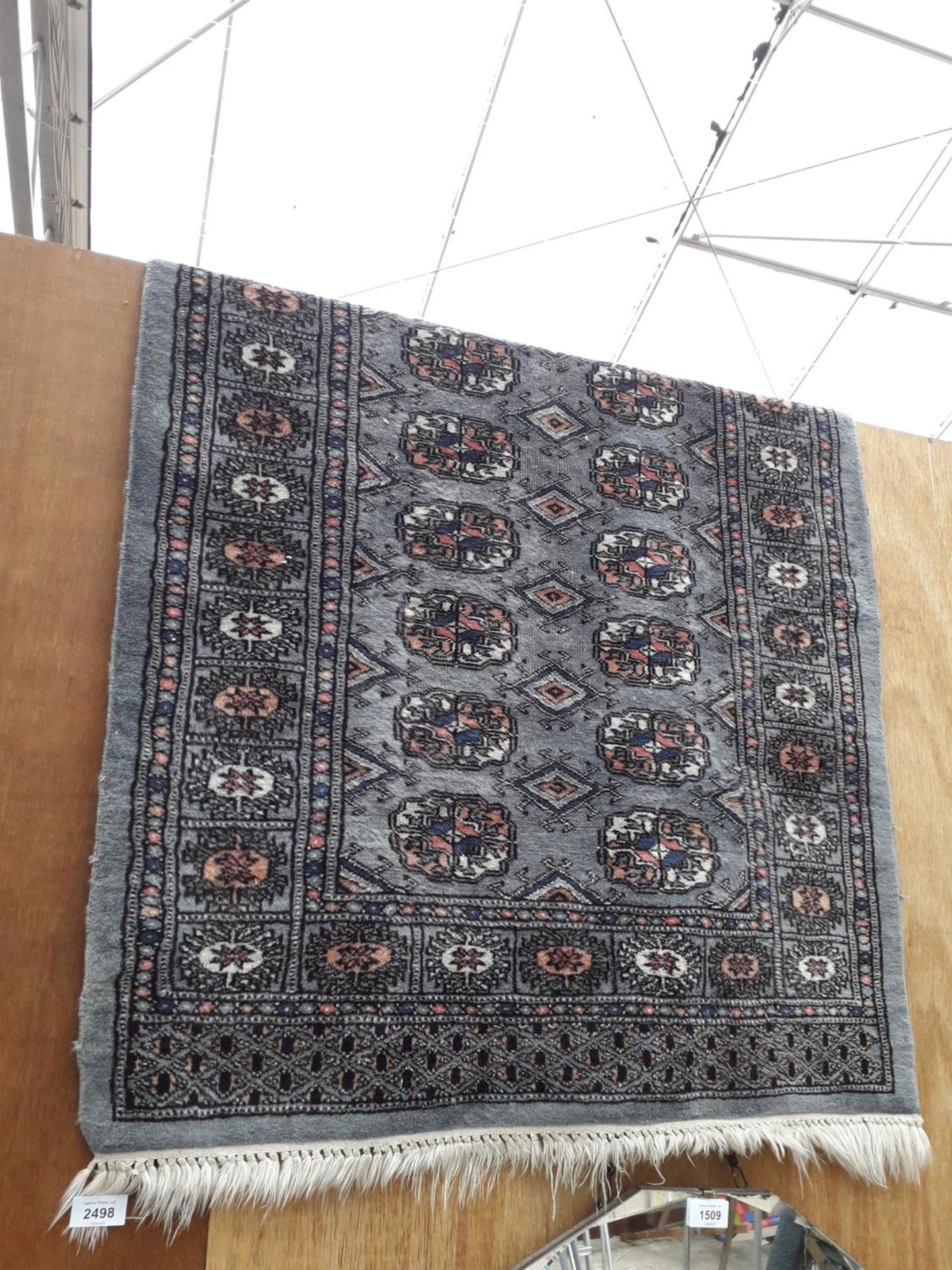 A BLACK PATTERNED FRINGED RUG