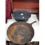 A CAST IRON COOKING POT AND A CAST IRON FRYING PAN
