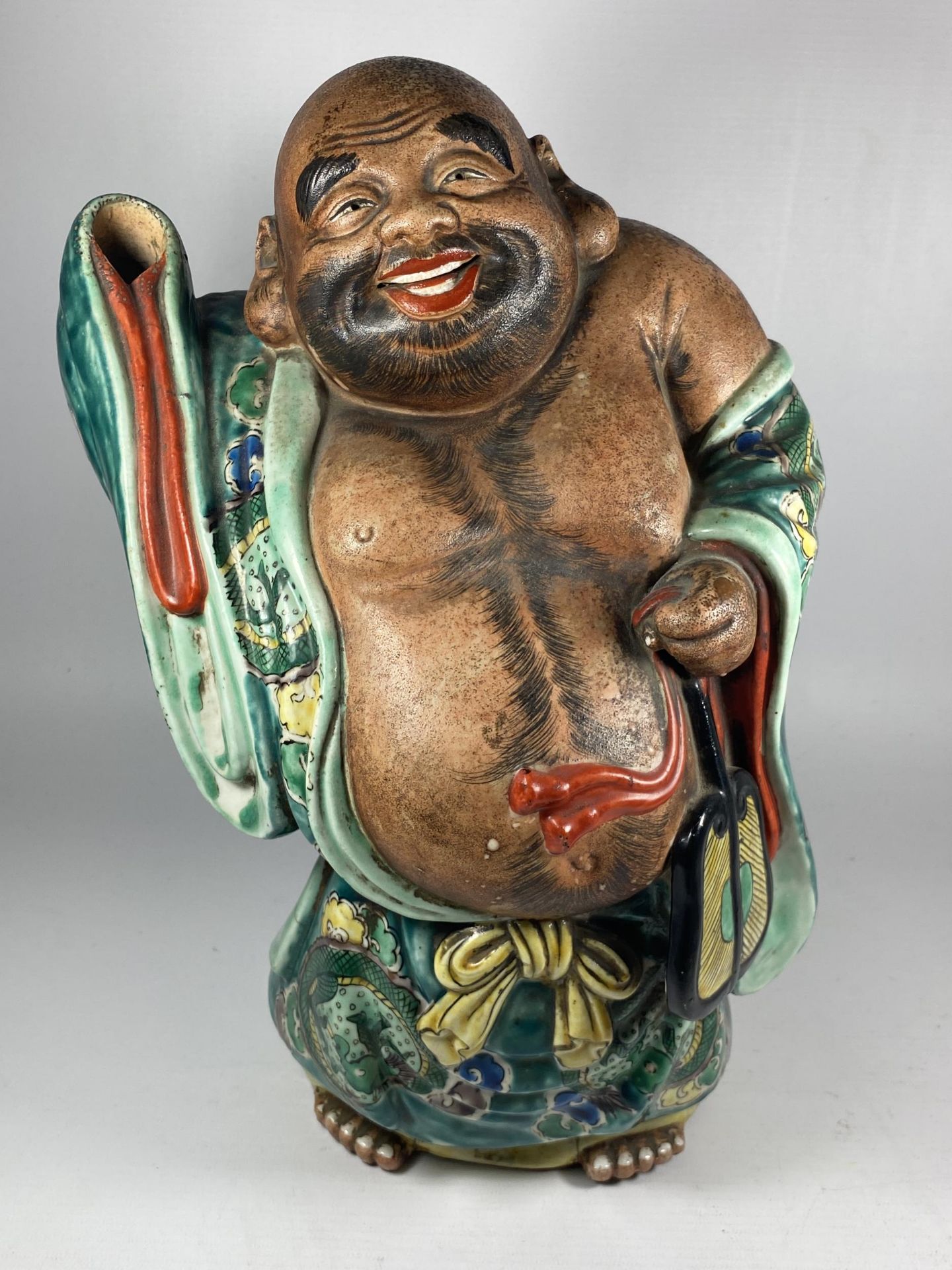 A LARGE JAPANESE MEIJI PERIOD (1868-1912) POTTERY MODEL OF HOTEI WEARING CHINESE DRAGON DESIGN ROBE,