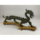 A 19TH CENTURY CHINESE BRONZE MODEL OF A DRAGON ON CARVED WOODEN BASE, LENGTH 30CM