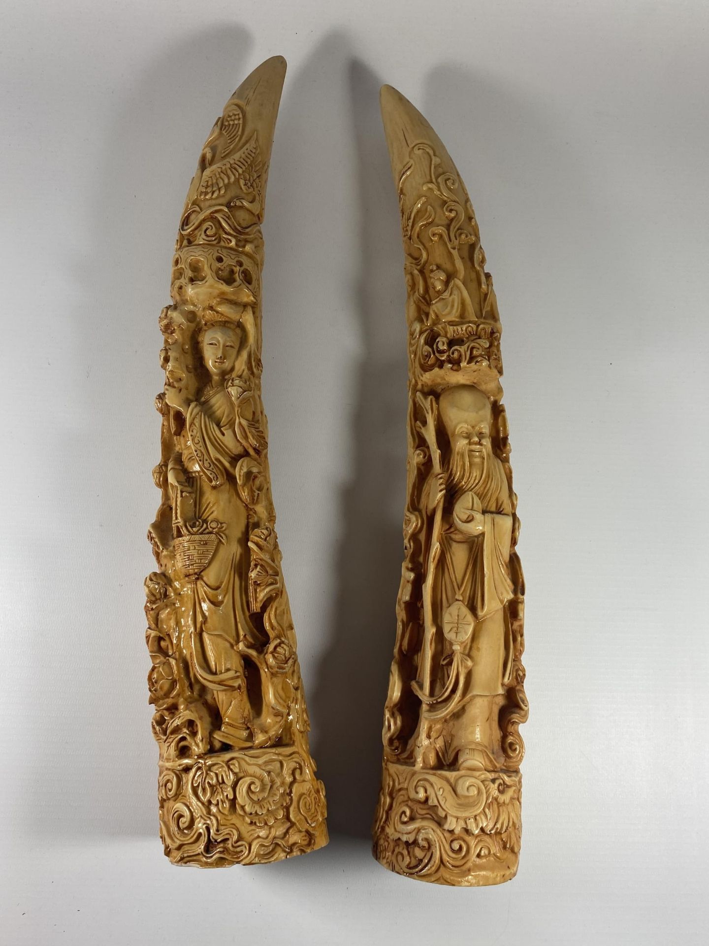 A PAIR OF LARGE RESIN ORIENTAL TUSKS, LENGTH 44CM