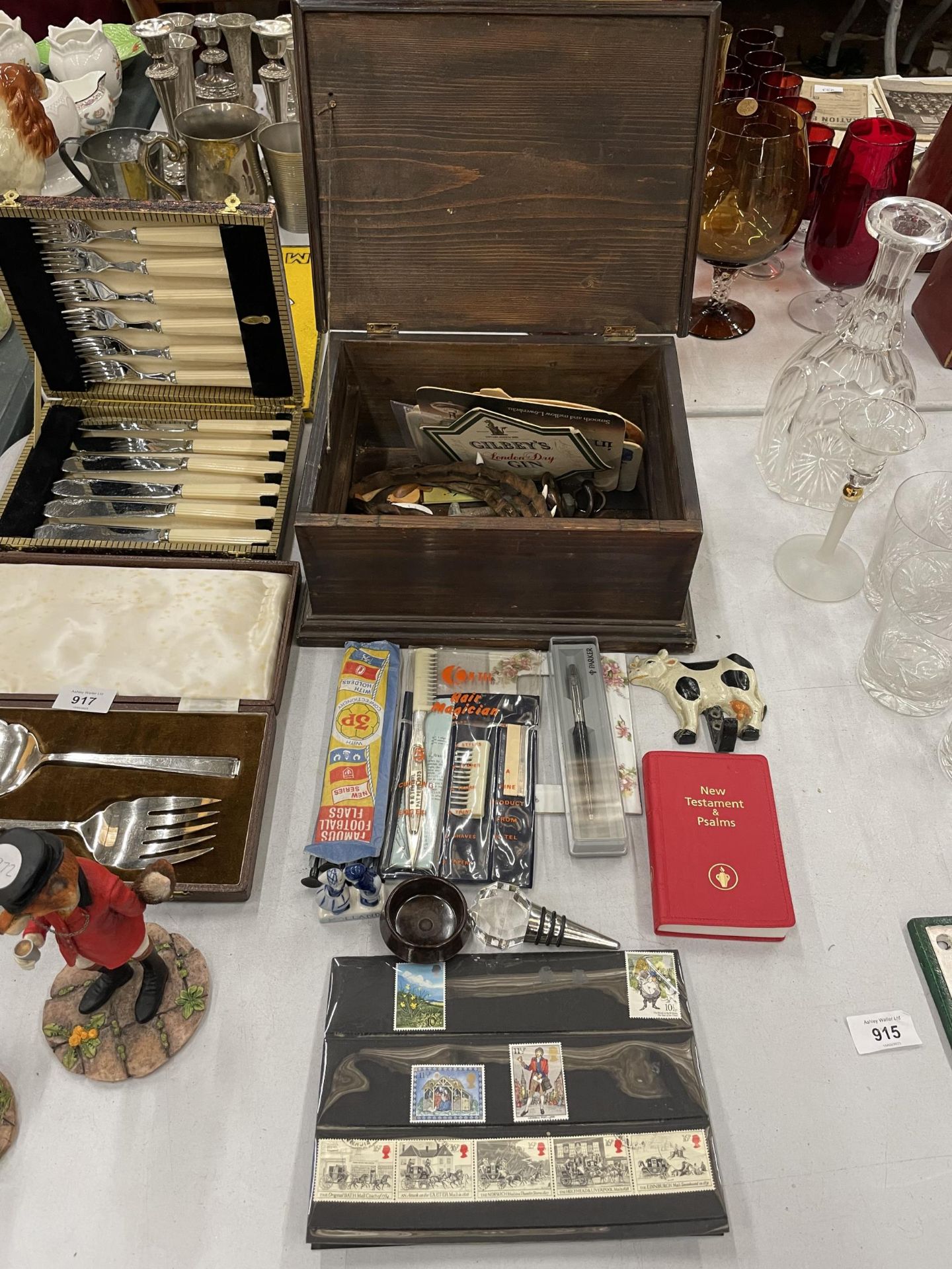 A WOODEN BOX CONTAINING VARIOUS ITEMS TO INCLUDE STAMPS, PENS, HOOKS, BEER MATS ETC