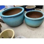 A PAIR OF GRADUATED TURQUOISE GLAZED TERACOTTA PLANTERS