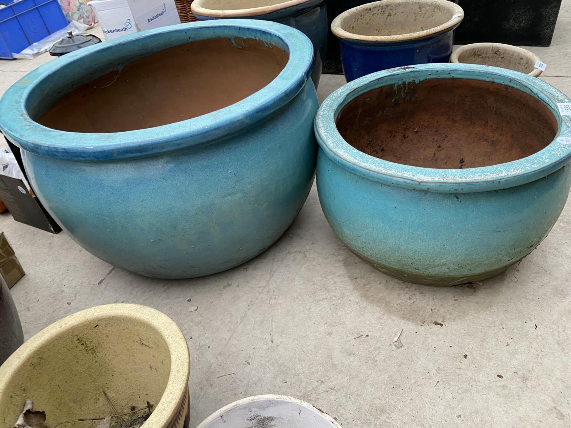 A PAIR OF GRADUATED TURQUOISE GLAZED TERACOTTA PLANTERS