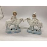 A PAIR OF STAFFORDSHIRE FIGURES OF A BOY AND GIRL SAT ON SHEEP