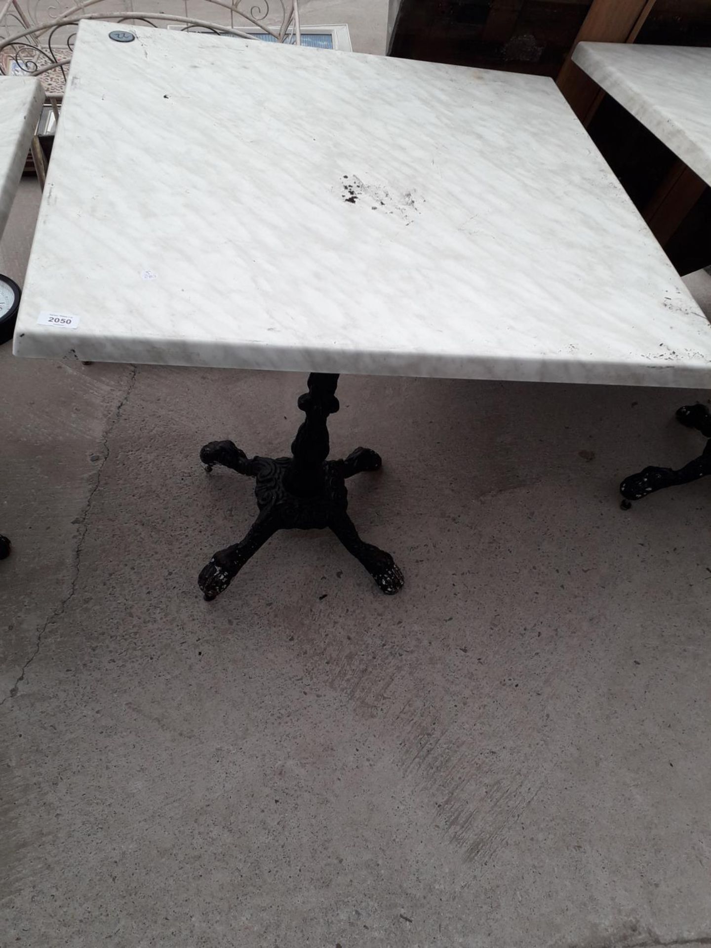 A PUB TABLE WITH WOODEN TOP AND CAST IRON TABLE BASE (79CM x 79CM)