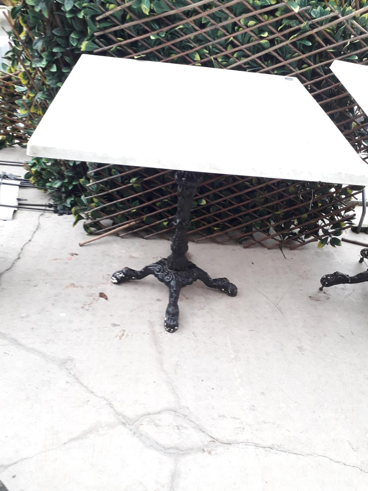 A PUB TABLE WITH WOODEN TOP AND CAST IRON TABLE BASE (79CM x 79CM)