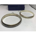 TWO SILVER BANGLES WITH SAFETY CHAINS IN A PRESENTATION BOX